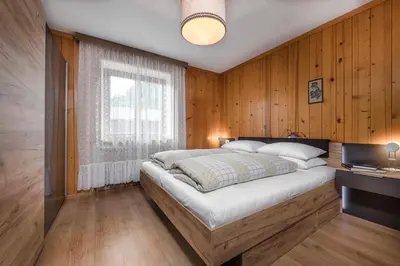 a bedroom with a bed in a wooden wall at Ringlerhof in Braies