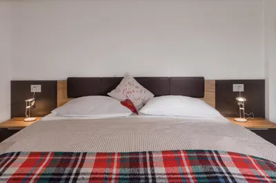a bed with two pillows on it with two lamps at Ringlerhof in Braies