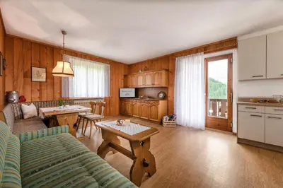 a kitchen and living room with a couch and a table at Ringlerhof in Braies
