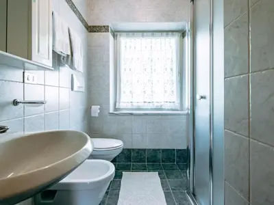 a bathroom with a sink and a toilet and a bed at Apartment Cincelli by Interhome in Pozza di Fassa