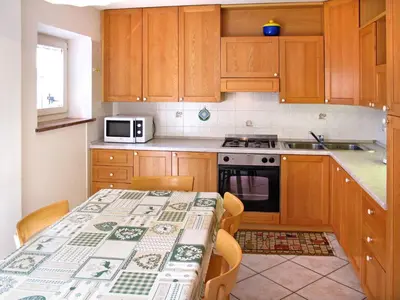 a small kitchen with a table and a microwave at Apartment Giuditta by Interhome in Pera