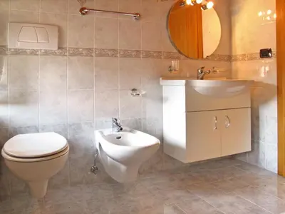 a bathroom with a toilet and a sink and a mirror at Apartment Giuditta by Interhome in Pera