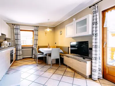 a dining room with a table and a couch at Apartment Carmen-3 by Interhome in Soraga