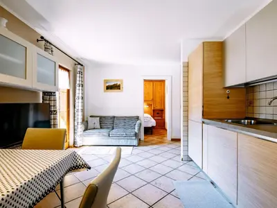 a kitchen and a living room with a table at Apartment Carmen-3 by Interhome in Soraga