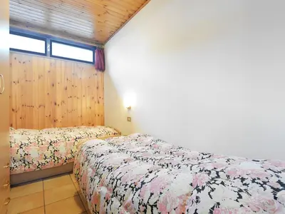 a bed in a room with wooden walls and ceilings at Apartment Cincelli - Marmolada by Interhome in Pozza di Fassa