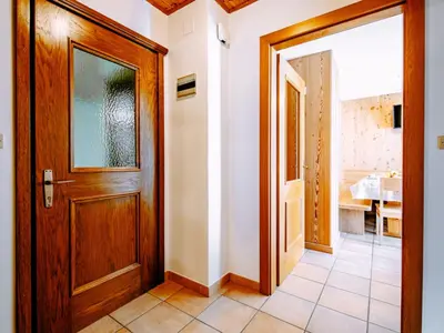 a hallway with a wooden door and a bathroom at Apartment Cincelli - Marmolada by Interhome in Pozza di Fassa