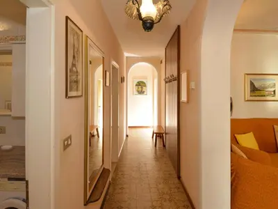 a corridor of a hallway with a couch and a chandelier at Apartment Casa Deluca by Interhome in Pozza di Fassa