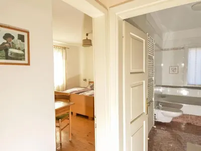 a bathroom with a door leading to a bedroom at Apartment Casa Deluca by Interhome in Pozza di Fassa