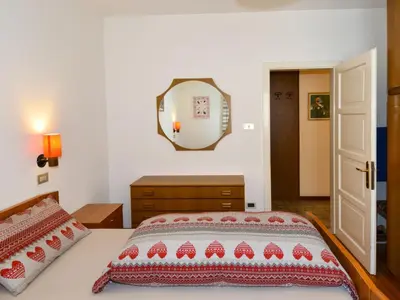 a bedroom with a bed and a mirror on the wall at Apartment Casa Deluca by Interhome in Pozza di Fassa