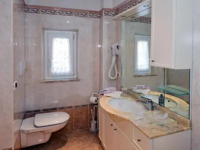 a bathroom with a sink and a toilet and a mirror at Apartment Casa Deluca by Interhome in Pozza di Fassa