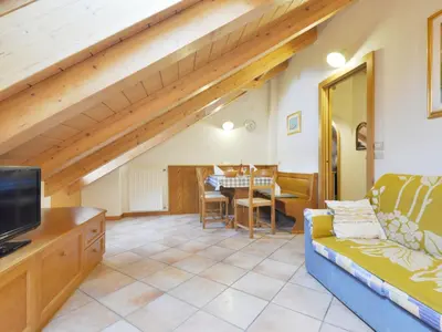 a bedroom with a large bed with a wooden headboard at Apartment Ardoney-2 by Interhome in Campitello