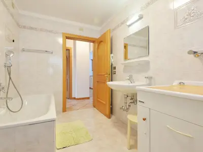 a bedroom with a large bed with white sheets at Apartment Ardoney-1 by Interhome in Campitello