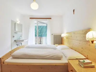 two beds in a room with wooden walls at Apartment Puntea by Interhome in Ortisei
