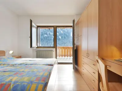 a bedroom with a bed and a bathroom with a toilet at Apartment Bernard-2 by Interhome in Campestrin