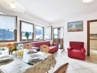 a living room with a red couch and a table at Apartment Bernard-2 by Interhome in Campestrin