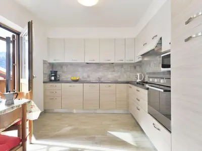 a kitchen with white cabinets and a microwave at Apartment Bernard-2 by Interhome in Campestrin