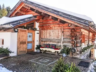 a log cabin in the middle of a green field at Apartment Chalet Baita Tabià Dolomites by Interhome in Bellamonte