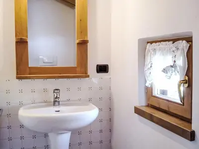 a bathroom with a sink and a mirror at Apartment Chalet Baita Tabià Dolomites by Interhome in Bellamonte