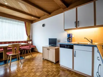 a living room with a table and a tv at Apartment Ornella-4 by Interhome in Ortisei