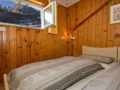 a bedroom with a bed in a room with a window at Apartment Deluca by Interhome in Pozza di Fassa