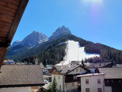 a view of a town with a mountain in the background at Apartment Deluca by Interhome in Pozza di Fassa