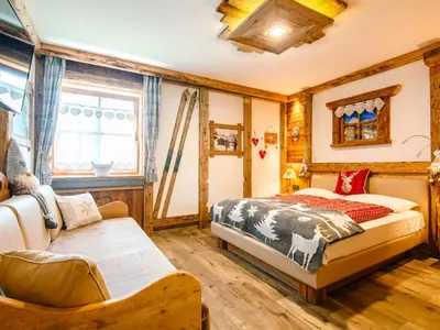 a bedroom with a bed in a room with wooden walls at Apartment Brunel-2 by Interhome in Pozza di Fassa