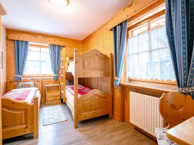 a bedroom with a bunk bed and a wooden cabinet at Apartment Brunel-2 by Interhome in Pozza di Fassa