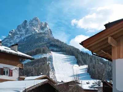 a pink building with wooden balconies on it at Apartment Brunel-2 by Interhome in Pozza di Fassa