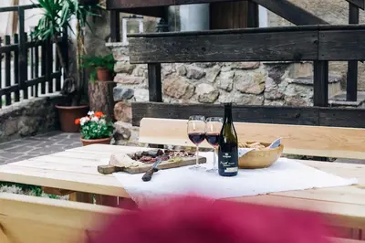 a table with a bottle of wine and two glasses at Untersteinhaus in Aldino