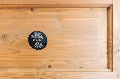 a wooden wall with a black sign on it at Untersteinhaus in Aldino