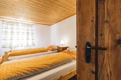 a bedroom with three beds and a wooden ceiling at Untersteinhaus in Aldino