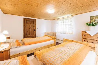 a bedroom with two beds and a wooden ceiling at Untersteinhaus in Aldino