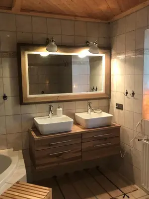 a bathroom with two sinks and a mirror and a tub at Bauernhaus Spathen in Santa Valburga St. Walburg