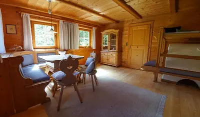 a living room with a table and chairs in a cabin at Bauernhaus Spathen in Santa Valburga St. Walburg
