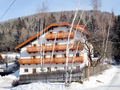 a building in the snow with trees in front of it at Apartment Zollerhof - OLA190 by Interhome in Valdaora di Sotto