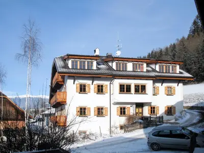 a white house with a car parked in front of it at Apartment Zollerhof - OLA190 by Interhome in Valdaora di Sotto