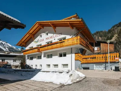 a large white building with a wooden roof at Apartment Cesa Micheluzzi - CZI712 by Interhome in Penia