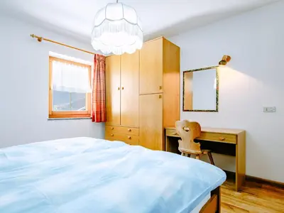 a bedroom with a bed and a desk and a mirror at Apartment Valentini by Interhome in Mazzin