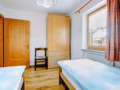 a bedroom with two beds and a window and a chair at Apartment Valentini by Interhome in Mazzin