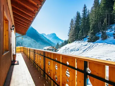 a wooden balcony with a view of a snow covered mountain at Apartment Valentini by Interhome in Mazzin