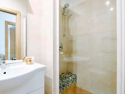 a white bathroom with a sink and a shower at Apartment Valentini by Interhome in Mazzin