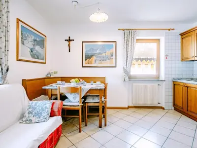 a room with a table and a kitchen with a cross on the wall at Apartment Valentini by Interhome in Mazzin