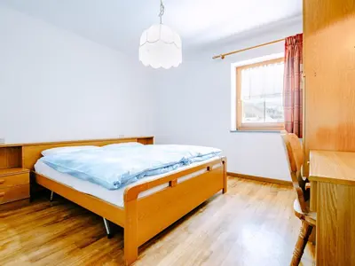 a bedroom with a bed and a desk and a window at Apartment Valentini by Interhome in Mazzin