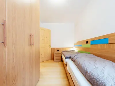 two beds in a bedroom with wooden dividers at Apartment Brunel - SOF772 by Interhome in Soraga
