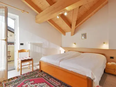 a bedroom with a bed in a room with wooden ceilings at Apartment Maura-1 by Interhome in Pozza di Fassa