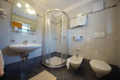 a bathroom with a shower and a toilet and a sink at Garni Flurida in Badia