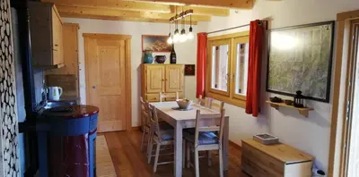 a kitchen with a table and chairs in a room at Tabià Fregona, Chalet Alpino con vista e stile tradizionale in Fregona