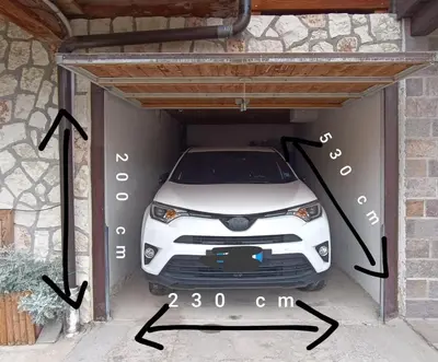 a white car is parked in a garage at Tabià Fregona, Chalet Alpino con vista e stile tradizionale in Fregona