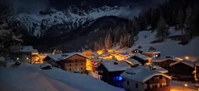 a small village in the snow at night at Tabià Fregona, Chalet Alpino con vista e stile tradizionale in Fregona