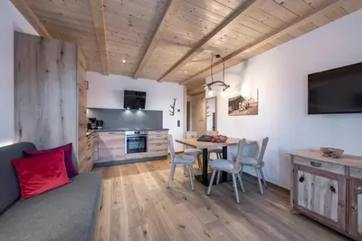 a kitchen and living room with a table and chairs at Gschlunerhof in Castelrotto
